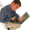 Man looks guilty on laptop in ladder
