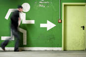 Man runs to fire exit in a corridor