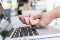 Woman holds hand after working too hard