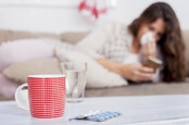 woman surrounded by piles of tissues uses smartphone app