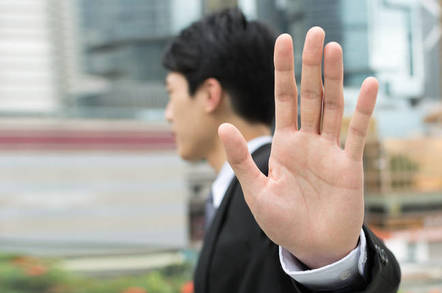 man holds hand up in gesture of rejection
