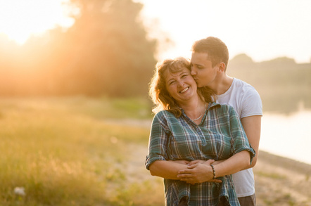 Mother being kissed by her adult son as he hugs her from behind – not at all inappropriate