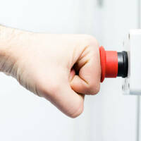 Picture of a person's fist hitting an emergency red button