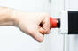Picture of a person's fist hitting an emergency red button