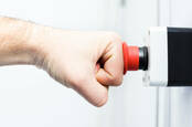 Picture of a person's fist hitting an emergency red button