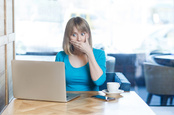 woman clicks the wrong thing on laptop, covers mouth from shock