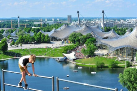 A boy plays on some railing on a hill overlooking Munich's Olympic grounds. - where the stadium will be built.