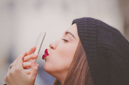 woman kisses her cellphone/mobile phone