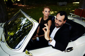 Wealthy couple sitting inside luxury car