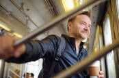 man smiles wryly during journey on bus