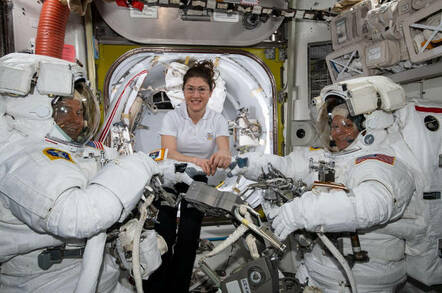 NASA astronaut Christina Koch (center) assists fellow astronauts Nick Hague (left) and Anne McClain