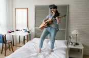 Woman sings, plays guitar while wearing VR headset