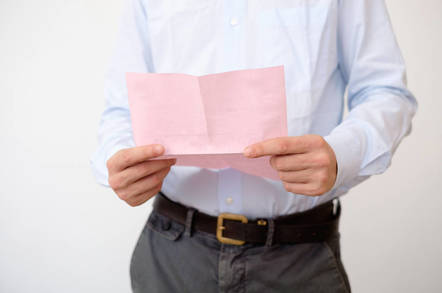 Shutterstock image of a man with a pink slip