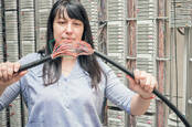 A woman holding a broken phone cable