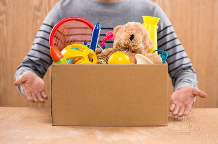 Male volunteer holding donation box with old toys