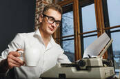 man with old-fashioned typewriter in office