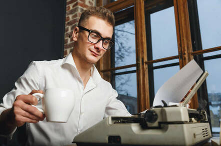 man with old-fashioned typewriter in office