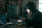 A woman in the classic "black hoodie hacker" shot