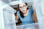 Shocked woman looking into fridge