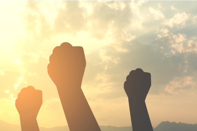 Silhouette fists raised to sky