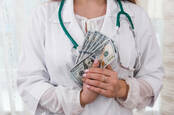 A doctor holding a stack of money