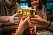 People clinking together beer glasses