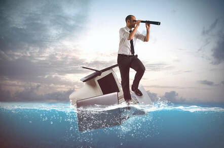 A guy adrift in an ocean on a laptop and monitor