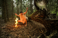 Primitive man makes fire in forest