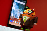 Android in a suit in front of mobile phone