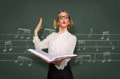 Someone singing in front of a blackboard of musical notes