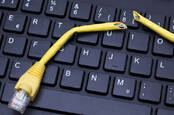 A cut-up ethernet cable sits on a keyboard