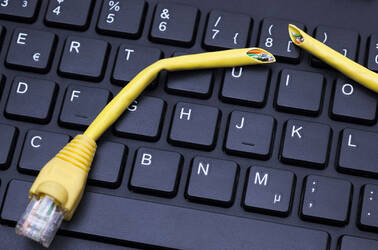 A cut-up ethernet cable sits on a keyboard