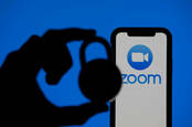Someone holding a padlock next to the Zoom phone app