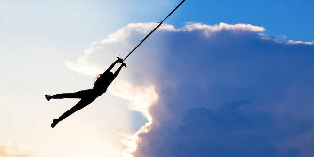 Person hanging on rope against sky