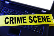 Computer with a police crime scene banner over it
