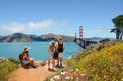 Three people looking at the Golden Gate Bridge, San Francisco, California