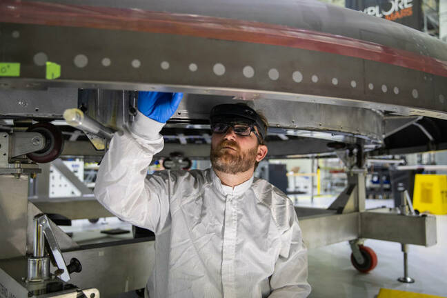 Eric Nolan, a technician working at the Kennedy Space Center, wears a HoloLens2 as he works on the heat shield for the crew module for NASA’s Artemis II mission. Image courtesy of NASA.