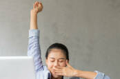 yawning woman in front of laptop