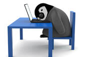 tired penguin head on laptop