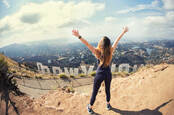 A woman standing by the Hollywood sign in California, USA