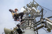 A technician climbing a cellphone tower