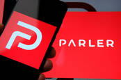 Someone holding a phone showing the Parler logo