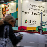 Someone walking by Slack's ad billboard in New York City