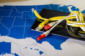 Ethernet cables tied up on top of a tablet and a map of the USA