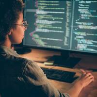 Someone programming on a PC besides the Python language logo