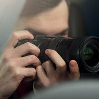 man takes pictures from a car as he follows his subject