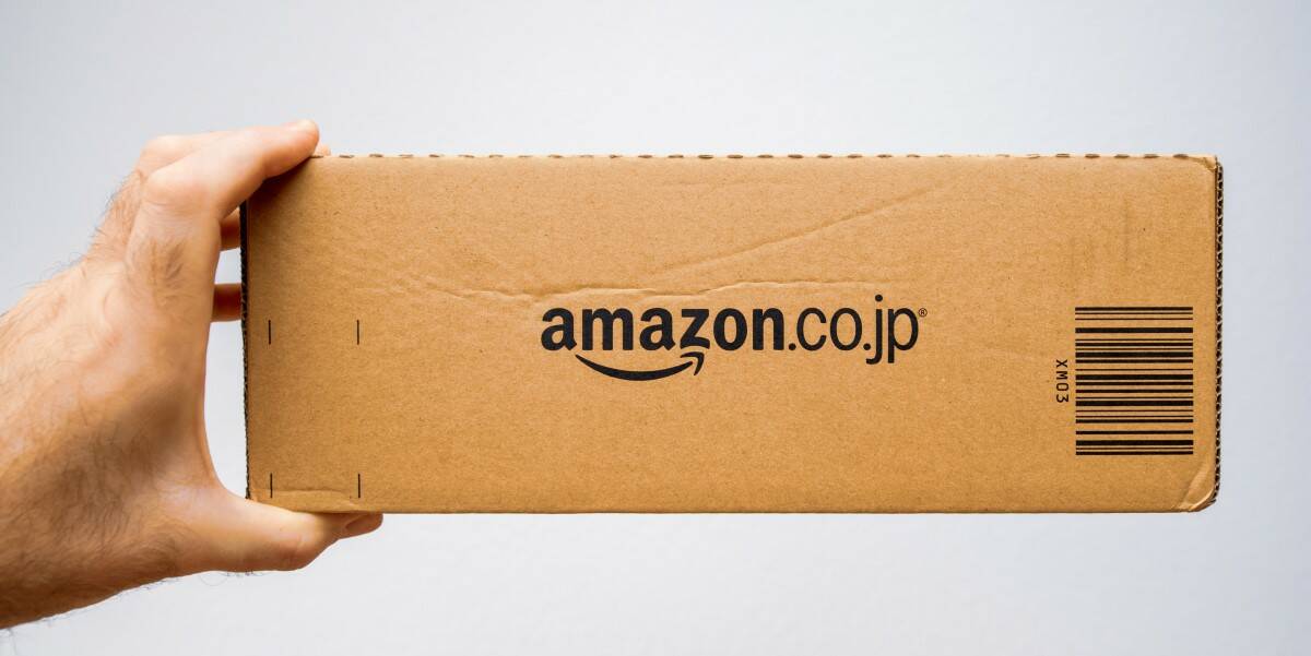 Amazon japan. Amazon stock Cardboard. Держит сбоку коробку.