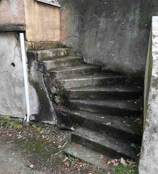 Photo of a stone stairway with a bricked-up wall at the top