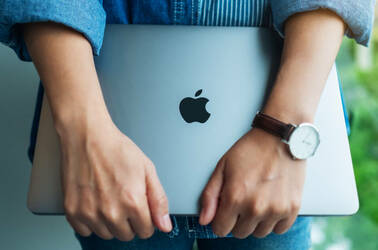 Someone holding an Apple laptop