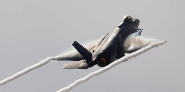 F-35C Lightning II in a high G maneuver, with condensation clouds over the wings and trails at the wing tips 